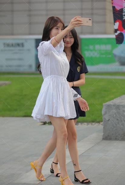 甜美风小姐姐身穿白色连衣裙，搭配黄色束脚凉鞋，让脚型更加完美