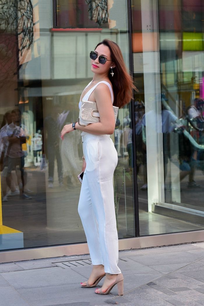 黑色|街拍:小姐姐身穿白色的吊带裙出行,青春又靓丽,阳光又时尚