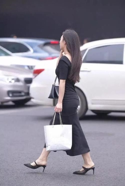 少女搭配一袭黑色长裙，知性温婉，性感大气