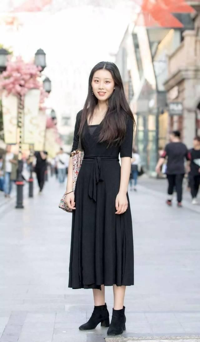 街拍牛仔短裤搭配黑色吊带背心，精致装扮为气质加分