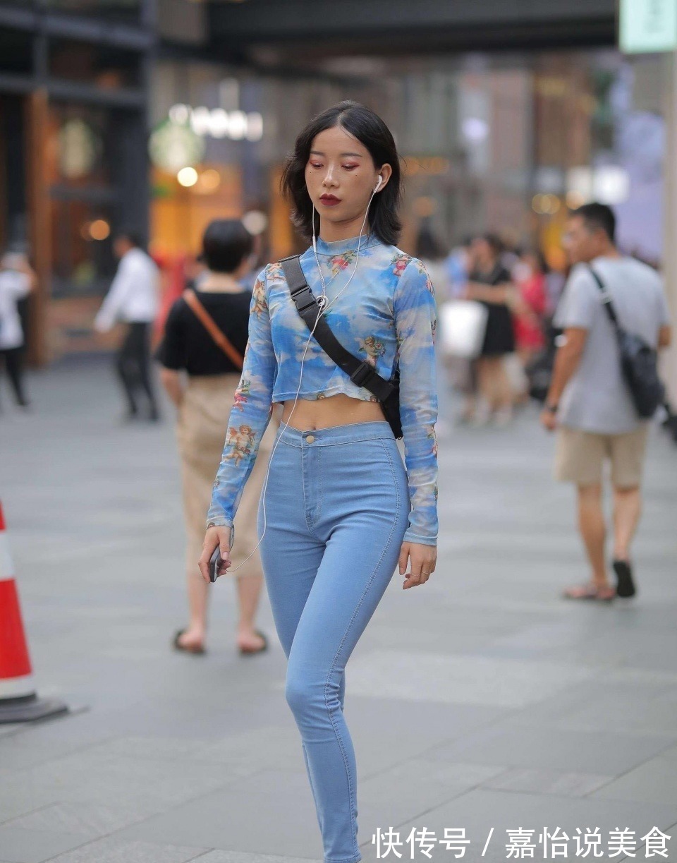 紧身牛仔裤 小姐姐身穿蓝色紧身牛仔裤,搭配一件扎染的上衣,看上去很时尚