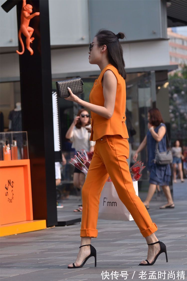 街拍 街拍:小姐姐橙色的套装,扎一个半丸子头型,显得人很精致!