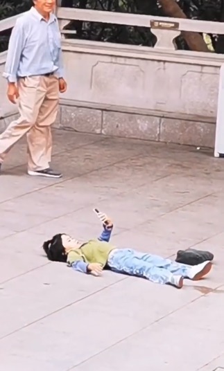 公共场合|大热天孩子躺在地上“玩手机”,路人议论纷纷,走近一看都乐了