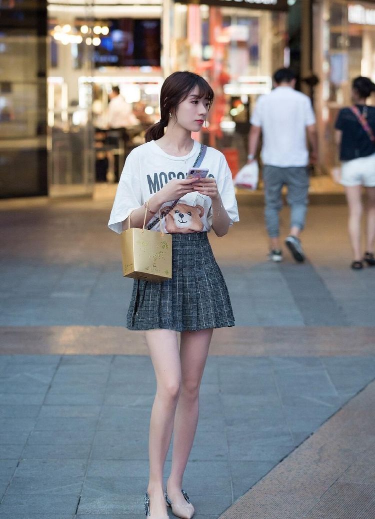 街拍:白色连衣裙穿出了美女的好身材,撩发的姿势也很是动人