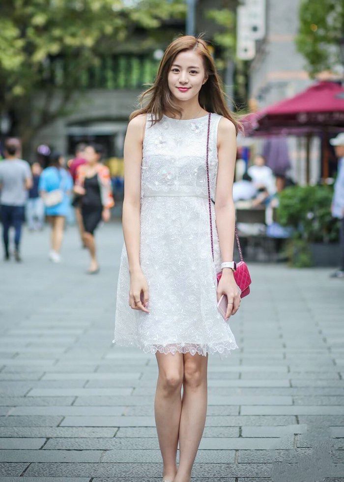 街拍:美女身穿黄色毛衣搭配小皮裙,笑容甜美可爱,非常时髦