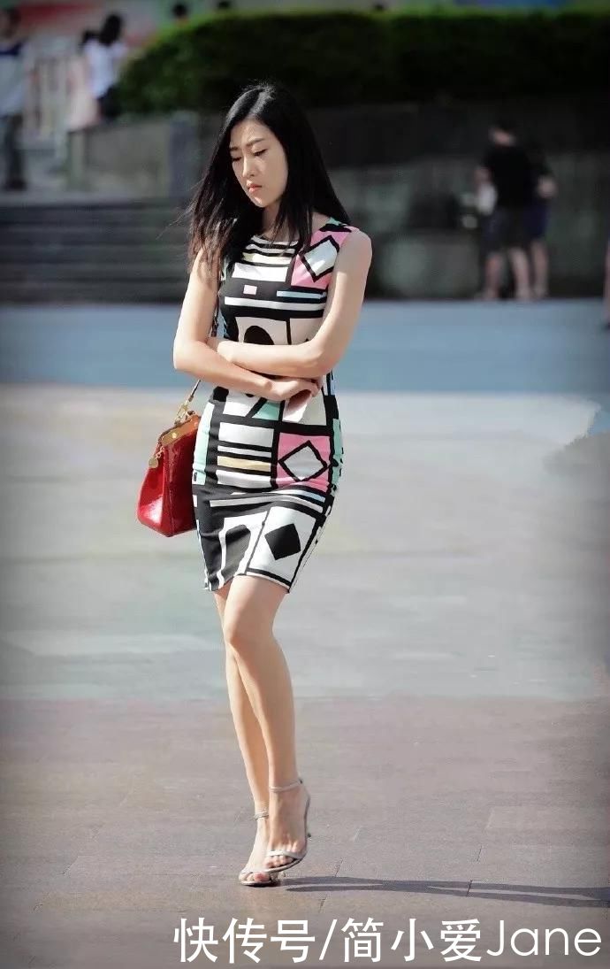 美女脚上踩着一双红色高跟凉鞋，带有绒毛的设计看上去温柔又时尚