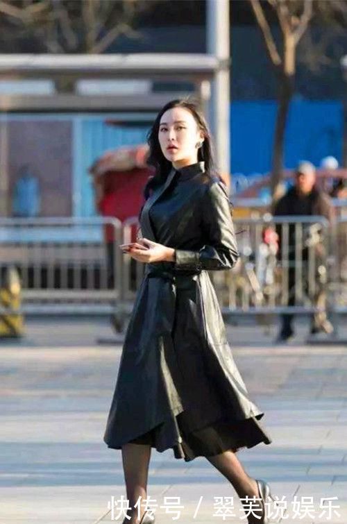 街拍小姐姐休闲款的白色黑袖上衣搭配精致的黑色短裙,美感十足