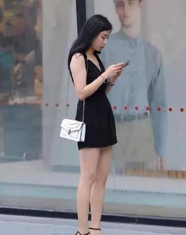 路人街拍，美女穿着一件v领的吊带，为自身的美丽加分