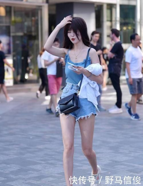 街拍小姐姐半袖上衣搭配黑色的短款下装,非常时尚具有美感