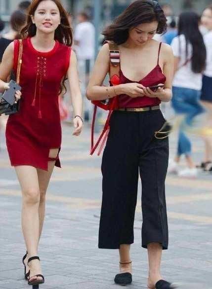 街拍小姐姐身穿红色吊带背心性感娇艳,搭配休闲裤帅气又随性