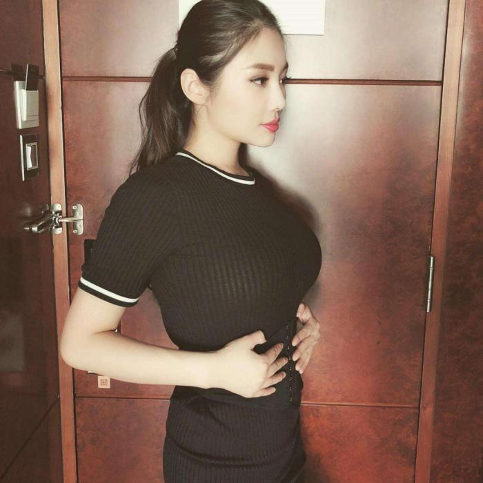 街拍小妹妹穿着浅绿色的V领上衣,苗条的身材勾勒出她优雅的身材