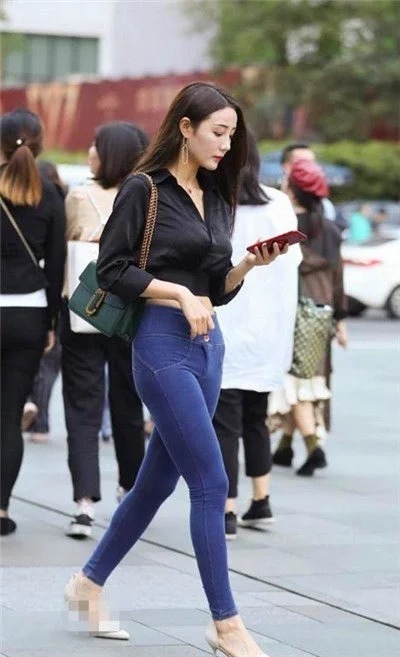 街拍:美女身穿白色抹胸上衣,身材高挑,一双大长腿吸睛无数