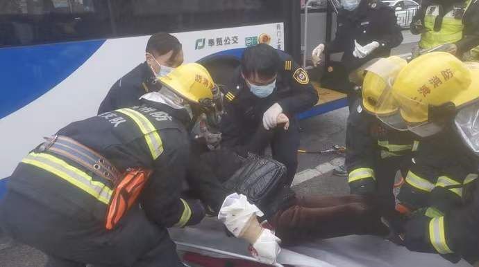 救援人员|图说│疼！女子骑车摔倒被压公交车轮下，消防员寒风中趴地救人