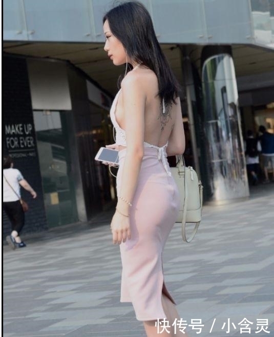 街拍美女身穿极简吊带露背上衣,配粉红紧身裙,优雅自信