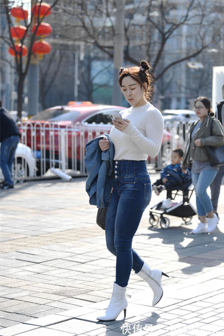 牛仔裤 街拍:美女搭配高腰牛仔裤,白色的尖头高跟短靴,更显身材高挑!
