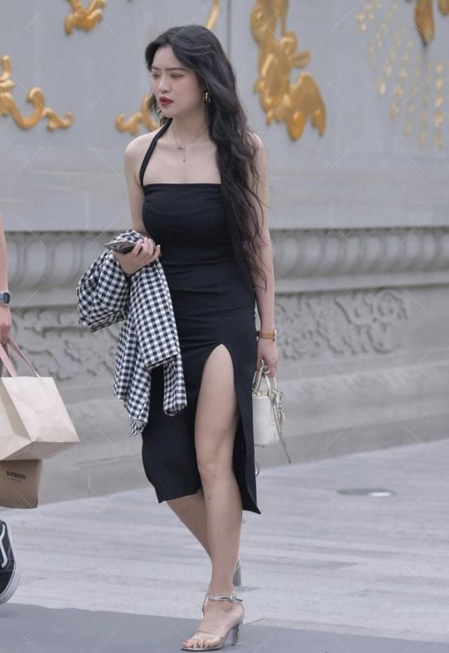 黑色吊带开叉裙格外吸引眼球，穿搭出的气质高雅，银色高跟鞋精致