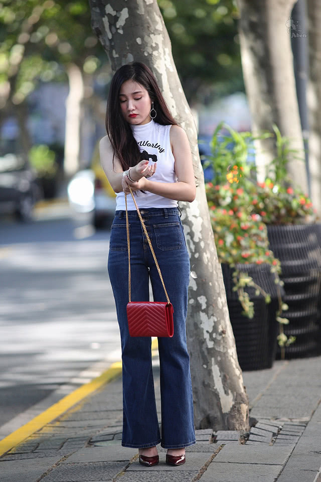 喇叭裤|街拍美女小姐姐无袖T恤配上素雅牛仔喇叭裤,尽显“御姐”风采