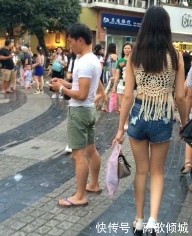 镂空|街拍:美女蓝色紧身高腰牛仔裤搭镂空线衣,给人时尚清凉的感觉