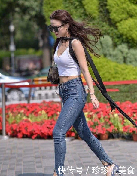 牛仔裤|街拍美女黑色短款皮夹克,搭配高腰的黑色牛仔裤,时尚有个性
