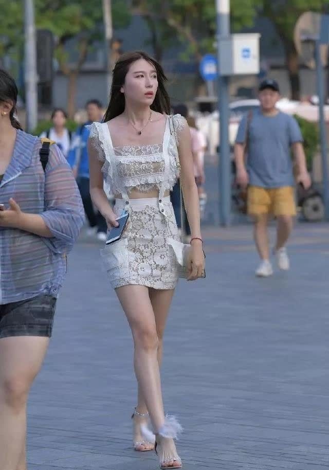 镂空套装 穿白色镂空套装短裙的清纯靓丽女孩, 飘逸的长发, 身姿迷人