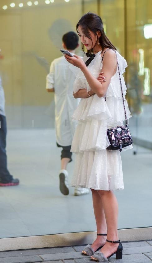 身穿蛋糕裙的小姐姐,裙身的版型立体,彰显出甜美俏皮的感觉