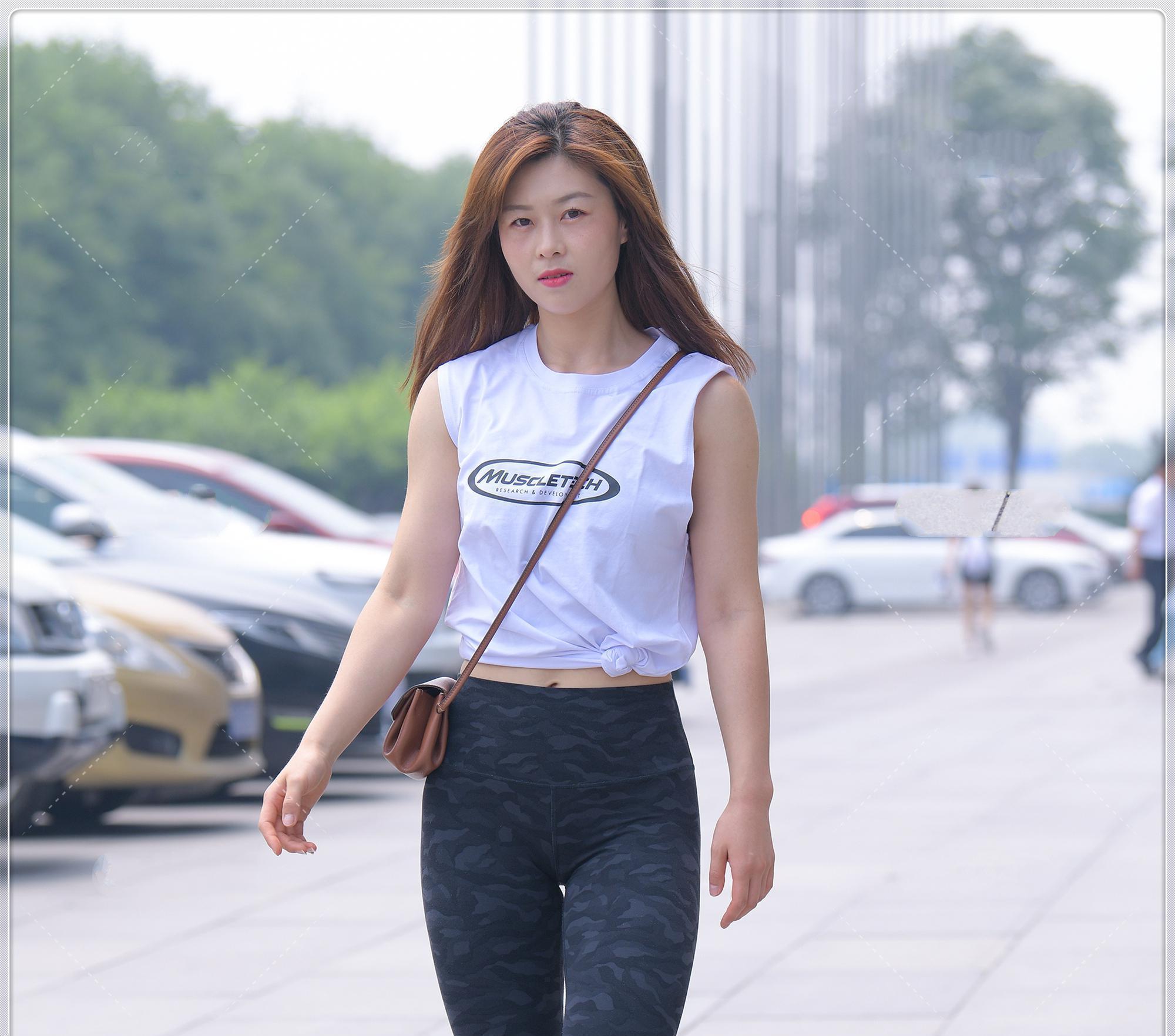 搭配|白色无袖圆领背心，黑色健身裤搭配复古包包，这身搭配酷范十足