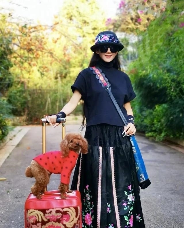 机场|60多岁的杨丽萍活出了自信,穿红色民族裙走机场,推竹筐好洋气