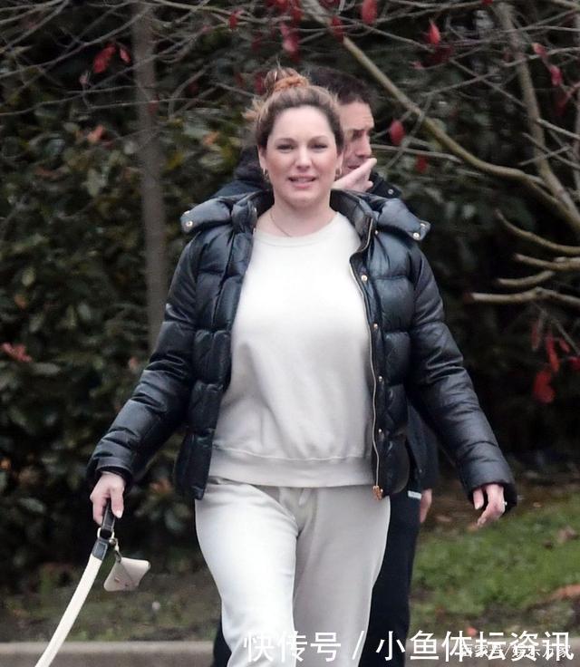 凯莉·布鲁克穿白色套装和黑色羽绒服外出遛狗很惬意