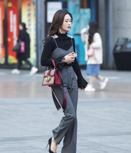 街拍小姐姐身穿一件白色短袖紧身T恤,搭配一条黑色牛仔短裤