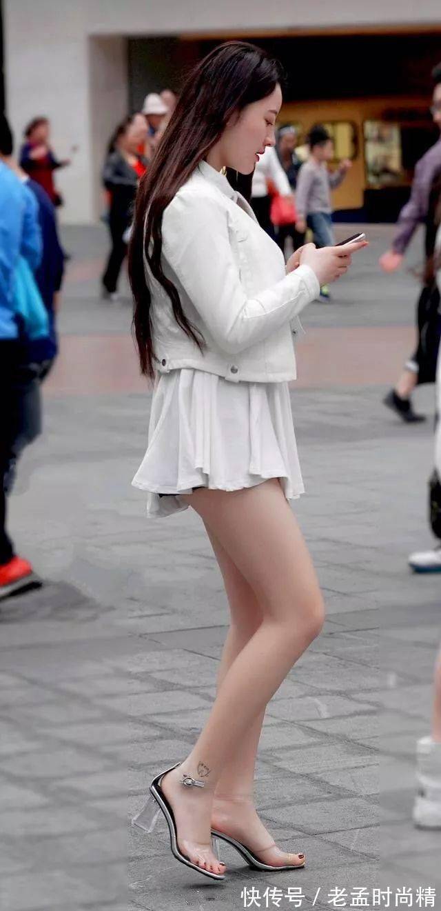 美女|街拍美女:美女穿着一双一字带的高跟凉鞋,透明的一字带能够增加她整体魅力