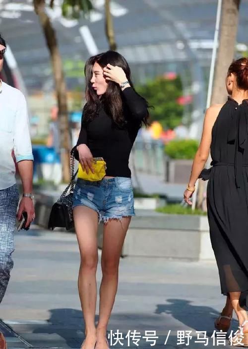 街拍小姐姐半袖上衣搭配黑色的短款下装,非常时尚具有美感