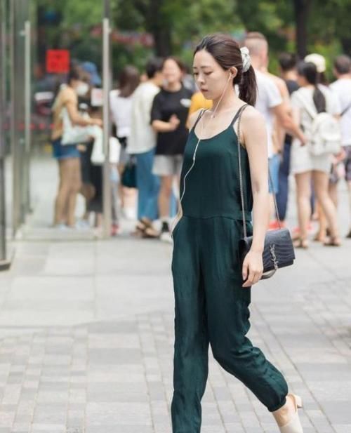 街拍小姐姐身穿一件白色短袖紧身T恤,搭配一条黑色牛仔短裤