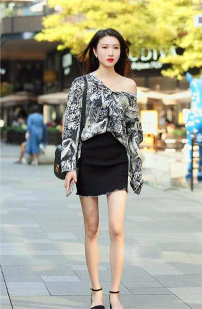 灰色|街拍长发小姐姐,身穿一件黑色的露肩上衣搭配一条灰色的半身裙,温婉可人