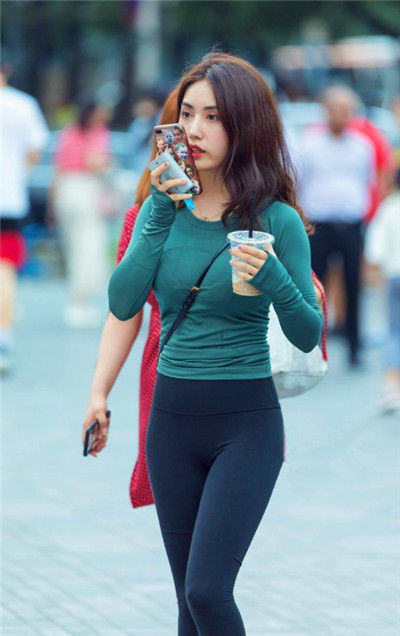 紧身裤|街拍优雅靓丽的小姐姐,绿色上衣搭配黑色紧身裤,美丽又动人