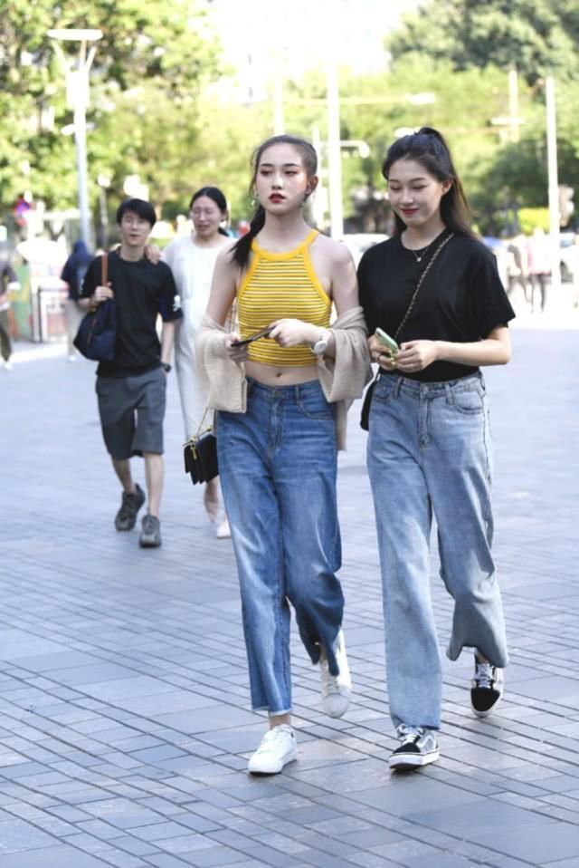 街拍：身材苗条的时尚美女，柔美的桔色上衣搭配牛仔裤，优雅大方