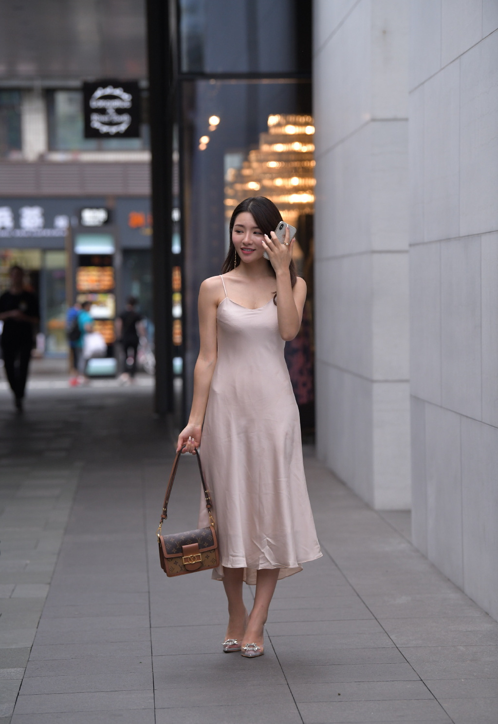 美女街拍:近肤色吊带裙真亮眼,搭配“透明酒杯鞋”,乍一看以为是“贵妇”