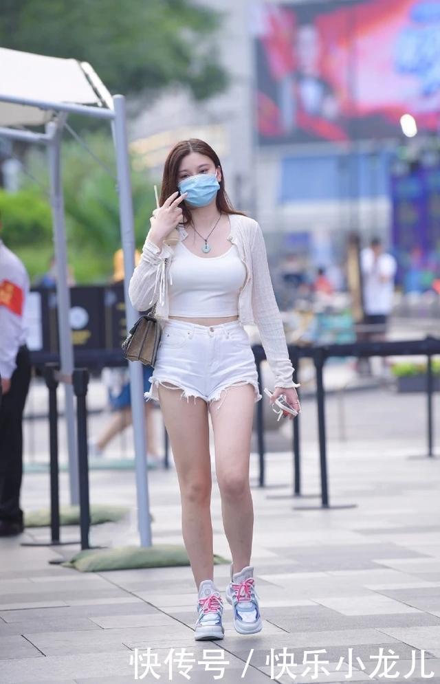 美女短款紧身吊带短袖,搭配碎边设计白色热裤,彰显时尚与魅力