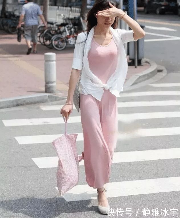 防晒衣|街拍紧身的粉色吊带连衣裙,搭配时尚白色防晒衣,优雅而性感