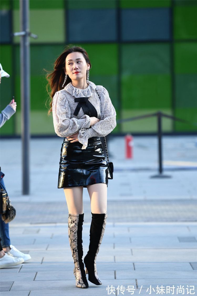 美女 街拍:美女高腰的黑色漆皮短裙,搭配拼接色的过膝靴,非常洋气!