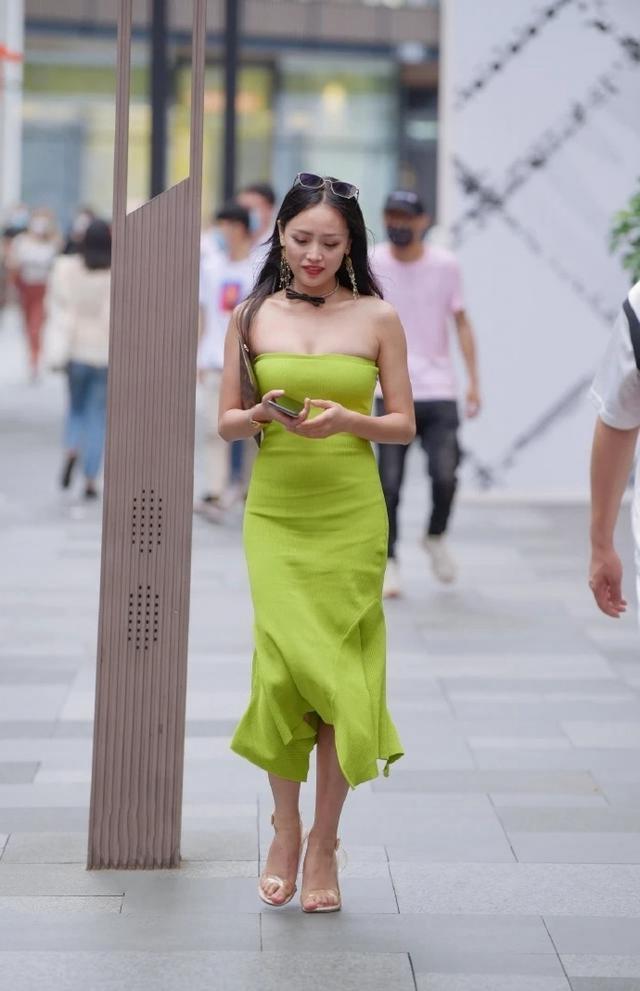 路人|路人街拍，美女搭配着绿色半身裙，十分吸晴