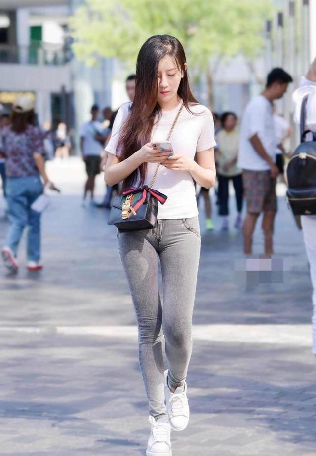 纯白色修身T恤搭配紧身牛仔裤，简单大方又不失优雅，显高又显瘦