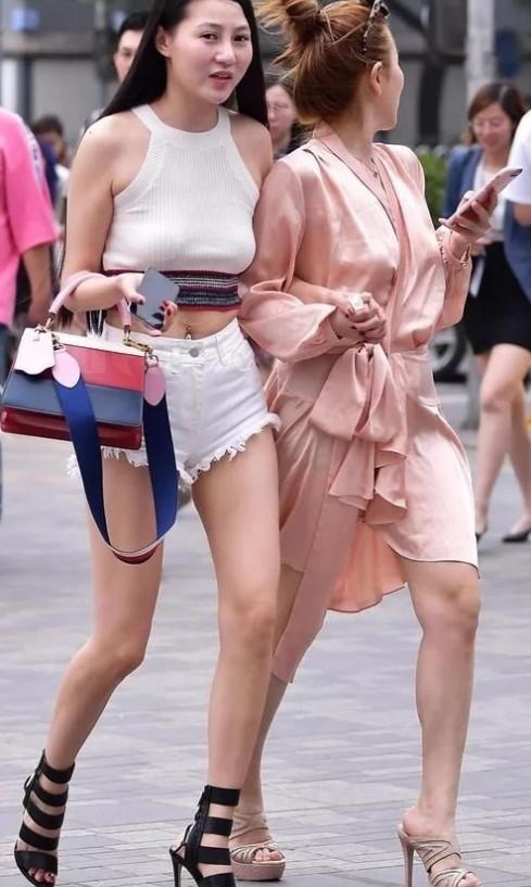 身穿|街拍:两个漂亮的小姐姐一起逛街,一个身穿短裤,一个像裹了睡衣