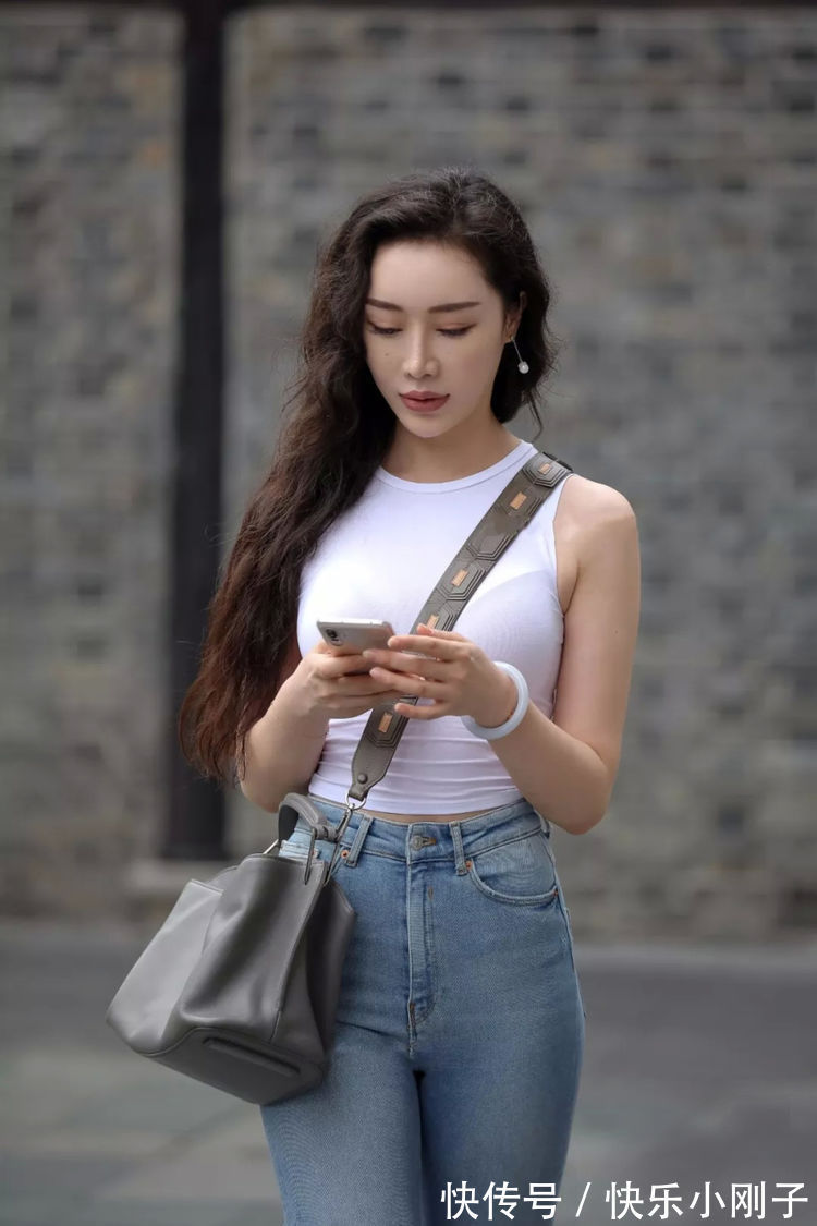 牛仔破洞裤 一件白色的背心,搭配高腰型的牛仔破洞裤,穿出了简约清新的美