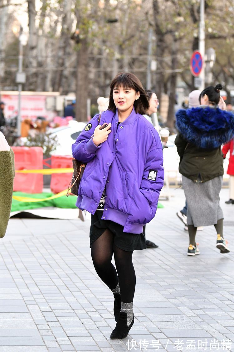 羽绒服 街拍:小姐姐蓝紫色的羽绒服,搭配黑色裙子和打底裤,时尚靓丽!