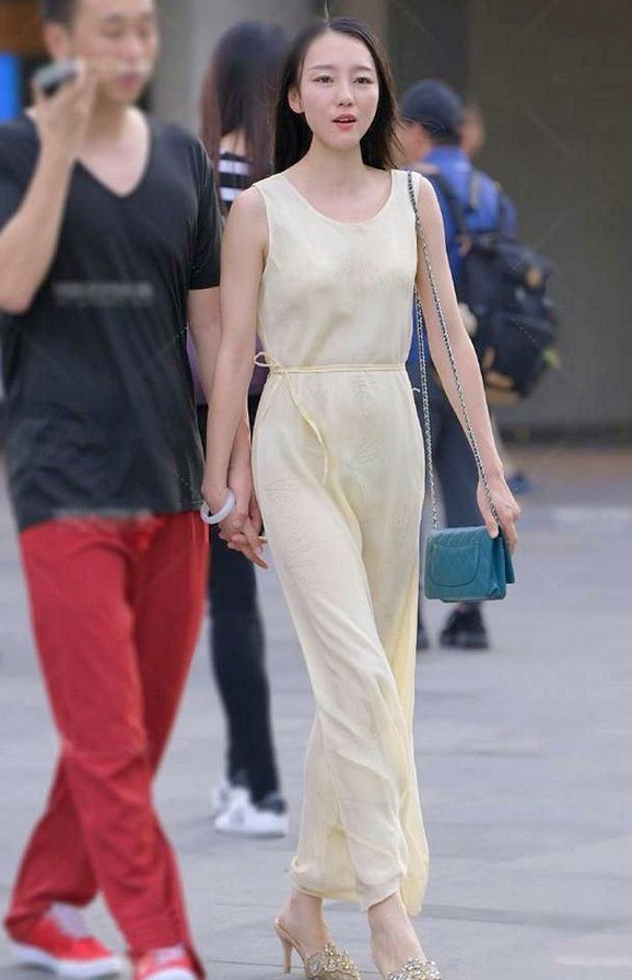 淡黄色的连体长裙，采用了修身的剪裁，展现出几分利落个性的美!
