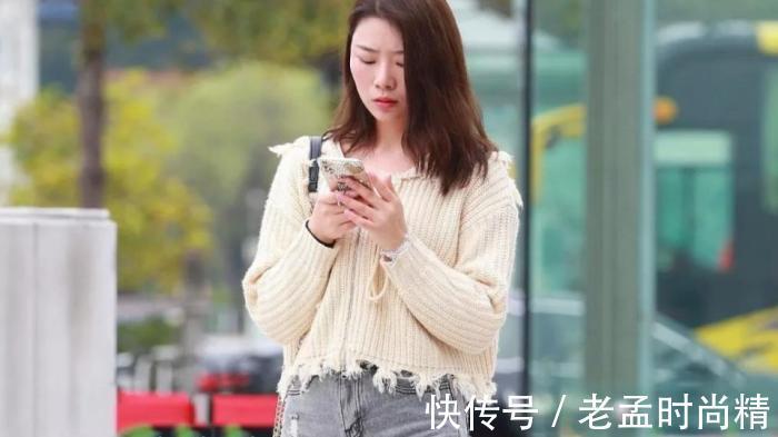 手机 街拍:米黄毛衫搭牛仔热裤的靓丽女孩,走路也不忘玩手机很危险!