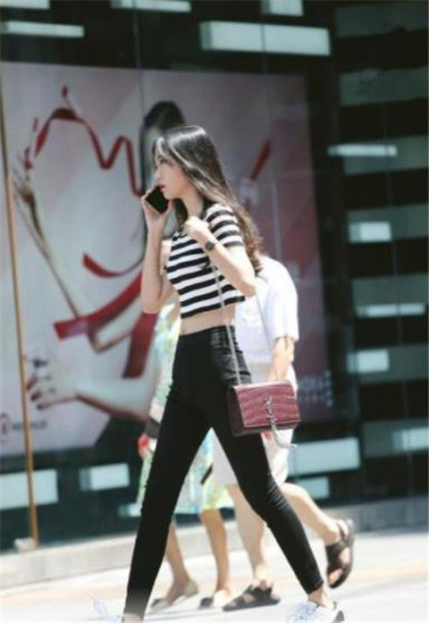 街拍貌美如花的小美女,身穿条纹短款上衣配紧身裤,尽显苗条好身材