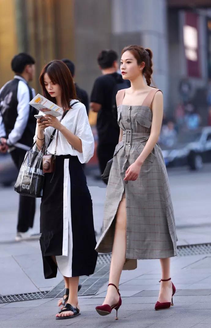小姐姐身上穿着这件吊带的连衣裙，有着一种工装的视觉效果