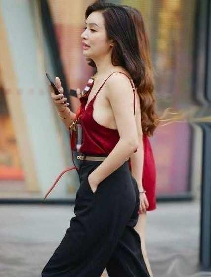 街拍小姐姐身穿红色吊带背心性感娇艳,搭配休闲裤帅气又随性