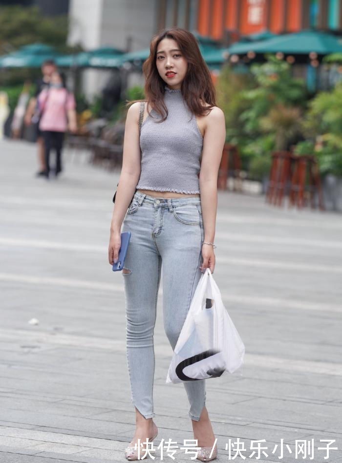 牛仔裤破洞细节的点缀,加入不规则的剪裁,提升整个造型的靓丽感